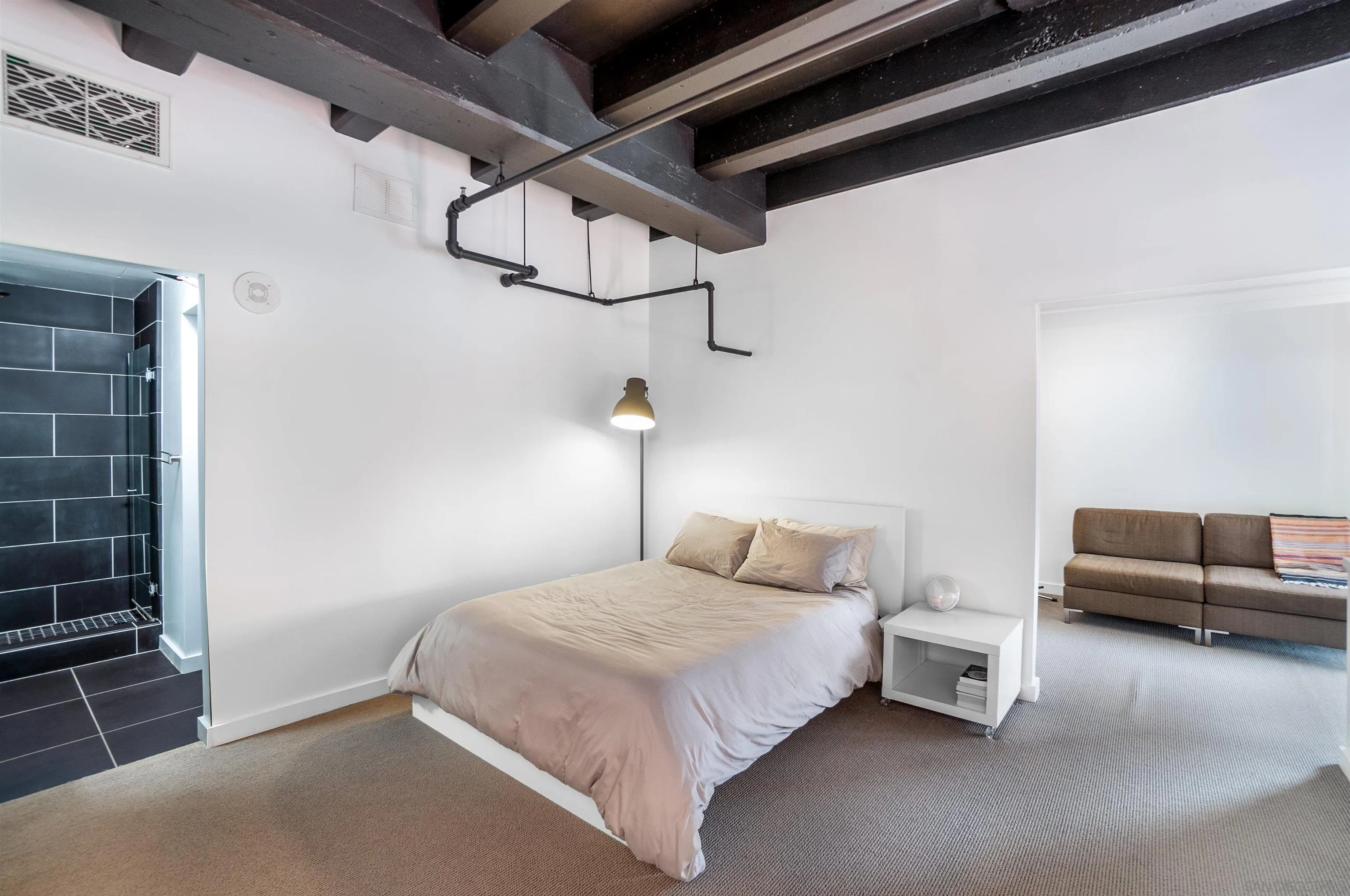 702 Ash Street, Unit 102 San Diego, CA 92101 - Photo 15 of 31 a bedroom with a bed couch and white walls