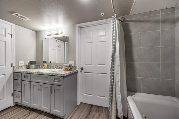 a bathroom with a granite countertop sink toilet and shower