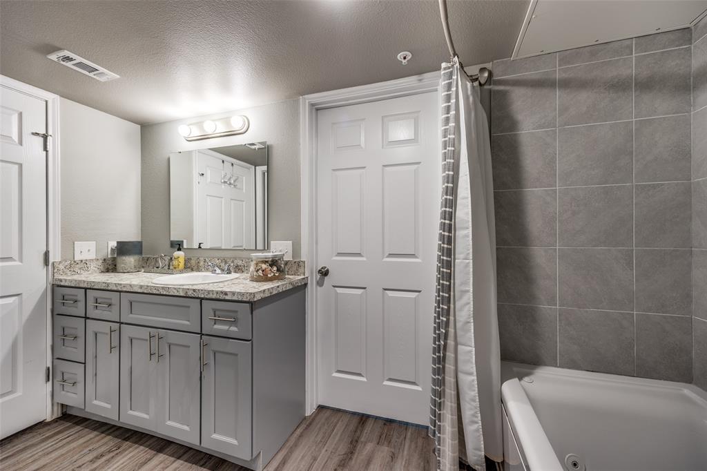6108 Abrams Road, Unit 205 Dallas, TX 75231 - Photo 3 of 12 Bathroom with a textured ceiling, vanity, shower / tub combo, and light wood-type flooring