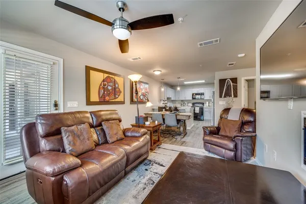 a living room with furniture kitchen view and a window