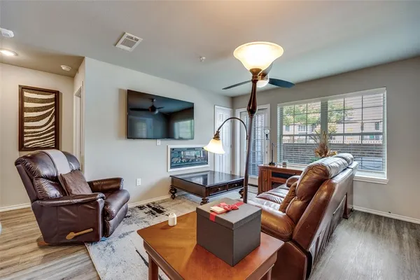 a living room with furniture a flat screen tv and a floor to ceiling window