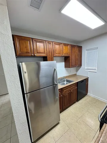 a kitchen with granite countertop a refrigerator and a sink