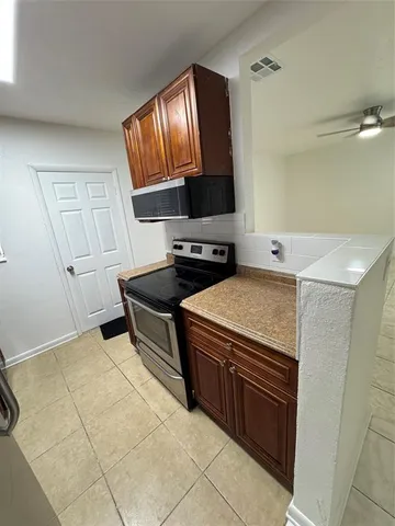 a kitchen with a stove sink and a mirror