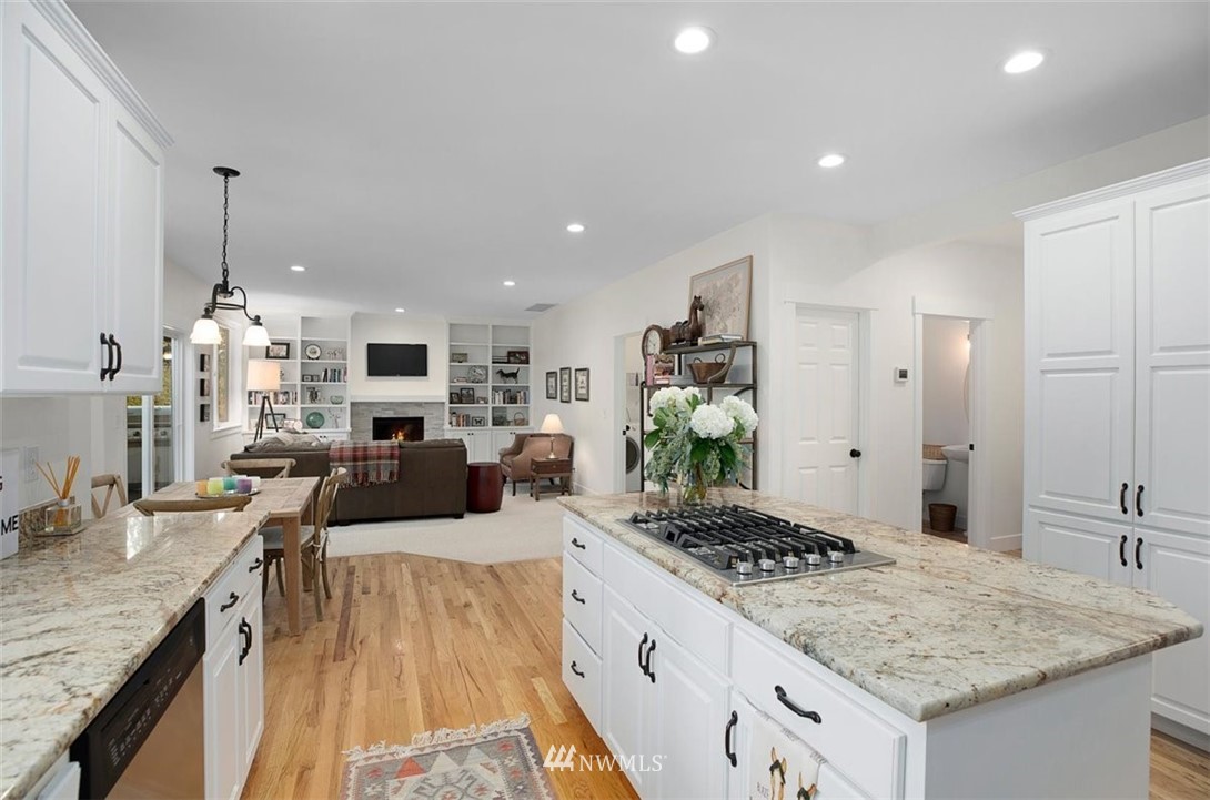 18906 Ross Road Bothell, WA 98011 - Photo 14 of 34 a kitchen with sink stove and white cabinets with wooden floor