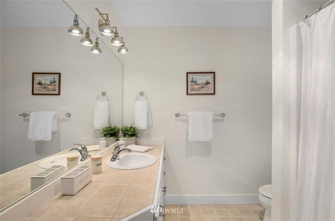 18906 Ross Road Bothell, WA 98011 - Photo 30 of 34 a bathroom with a granite countertop sink a mirror and a shower