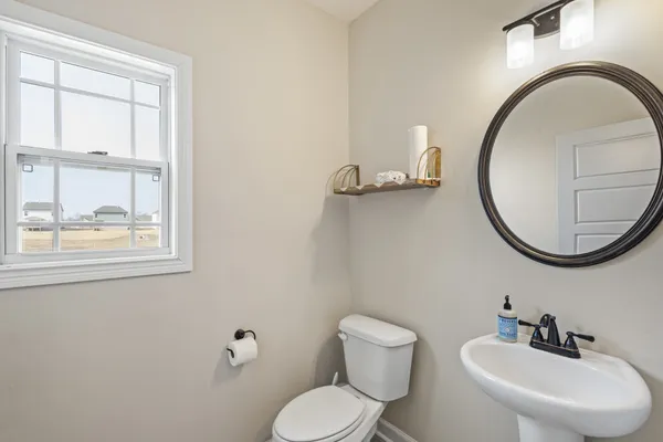 a bathroom with a toilet a sink and a mirror