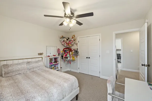 a bedroom with a bed and a ceiling fan