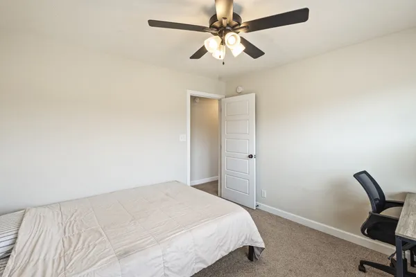 a bedroom with a bed chandelier and a window