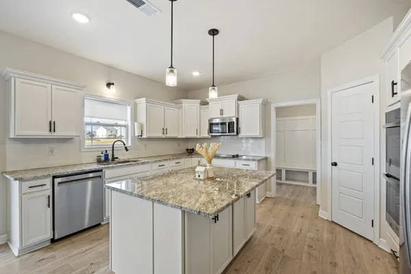 a kitchen with stainless steel appliances granite countertop a sink stove and refrigerator