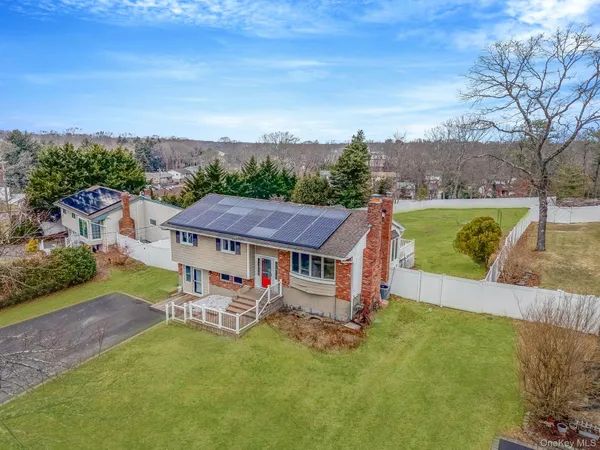 an aerial view of a house with swimming pool garden and trees