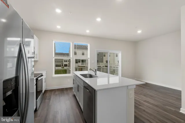 a kitchen with granite countertop a sink and refrigerator