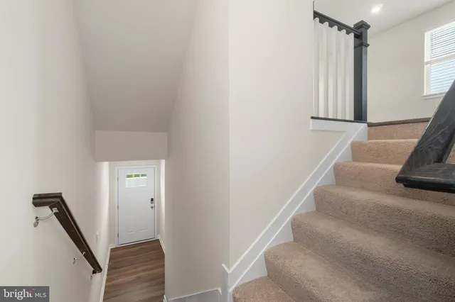 a view of staircase with white walls and a window