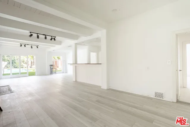 a view of a hallway with wooden floor and a cabinet