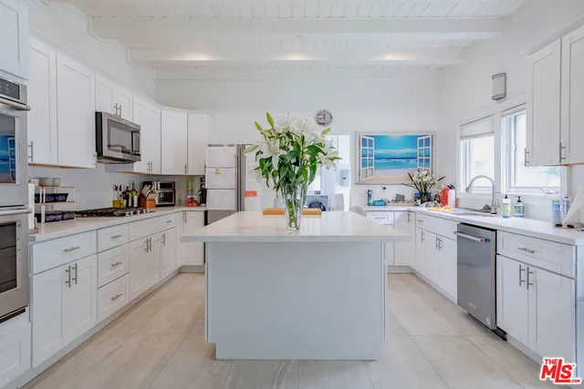 a kitchen with stainless steel appliances a sink window and cabinets