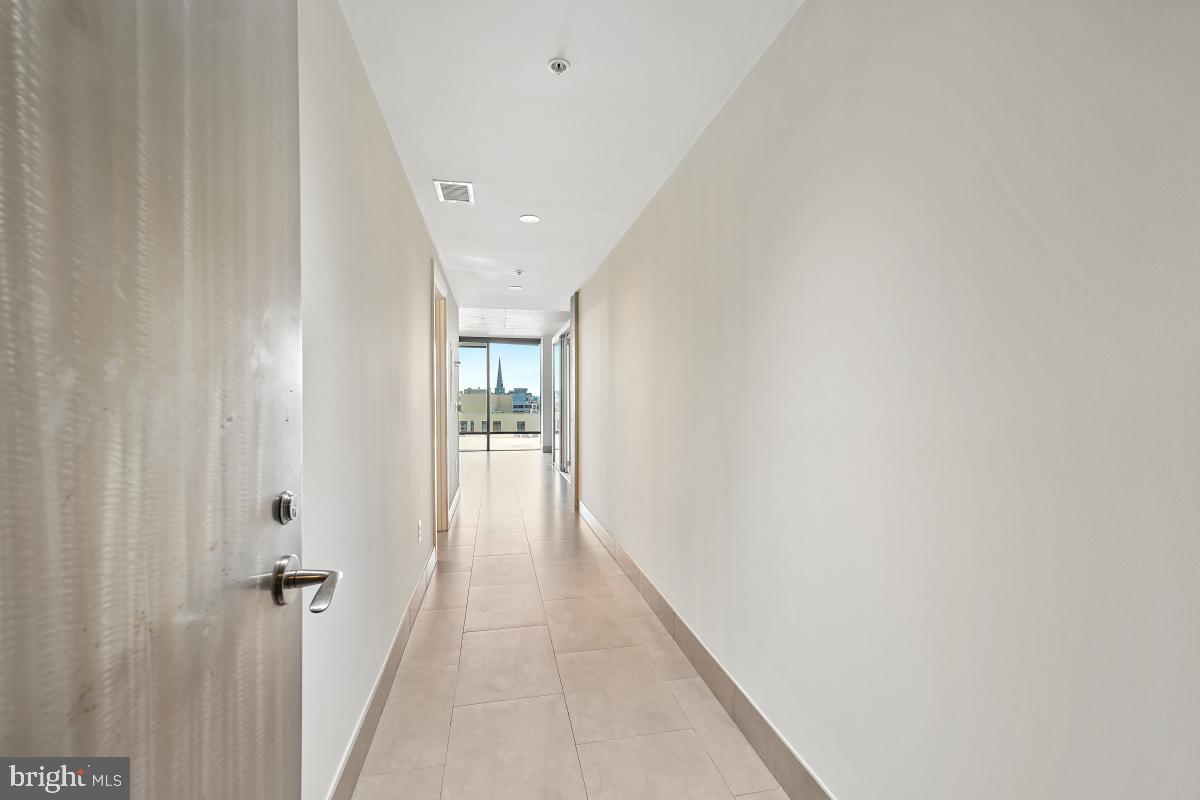 1133 14th Street Northwest, Unit 1103 Washington, DC 20005 - Photo 20 of 39 a view of a hallway with wooden floor and a bathroom