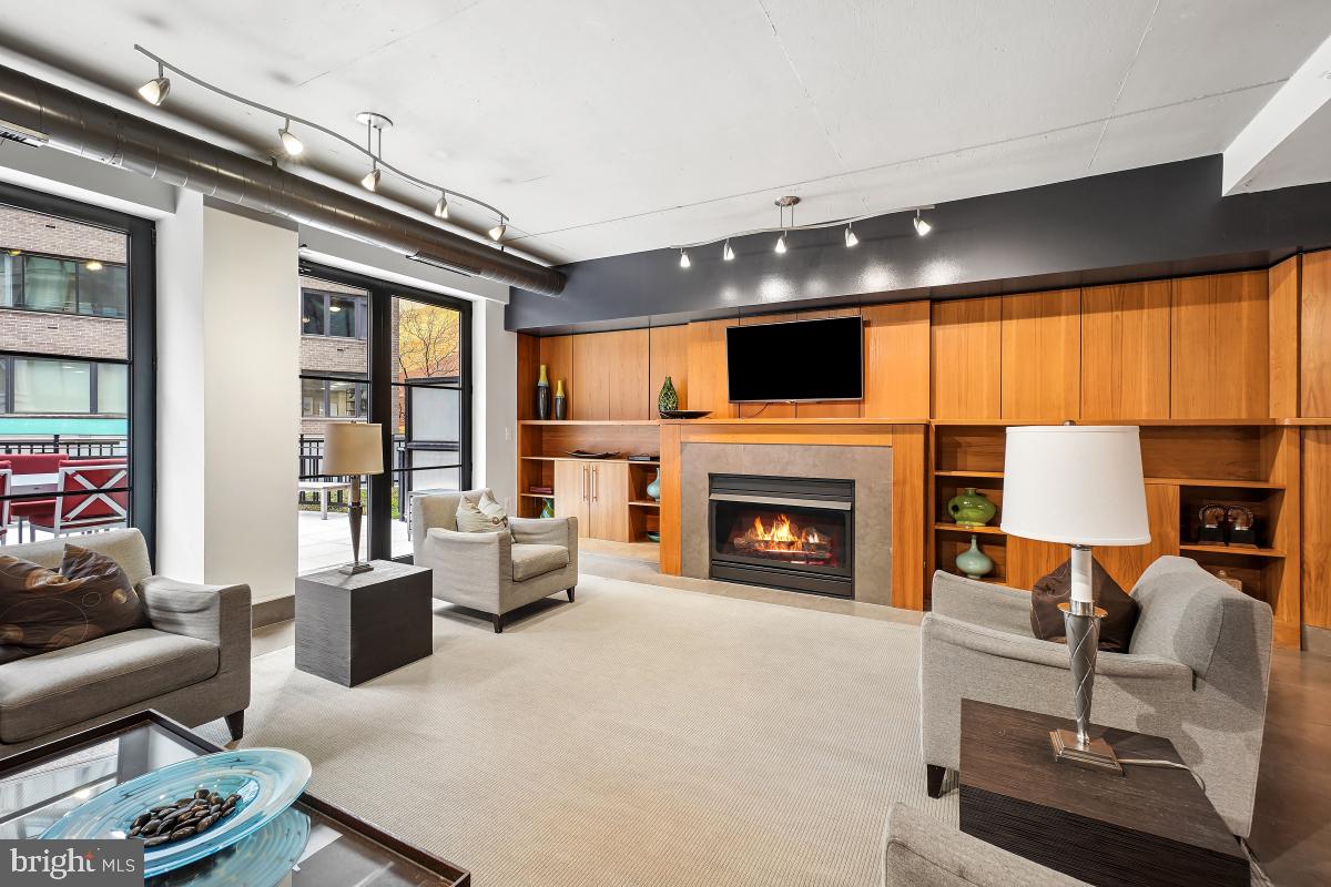 1133 14th Street Northwest, Unit 1103 Washington, DC 20005 - Photo 32 of 39 a living room with furniture a fireplace and a flat screen tv