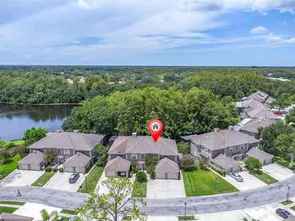 an aerial view of a house with a garden and lake view