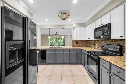 a kitchen with stainless steel appliances granite countertop a stove a sink and a microwave