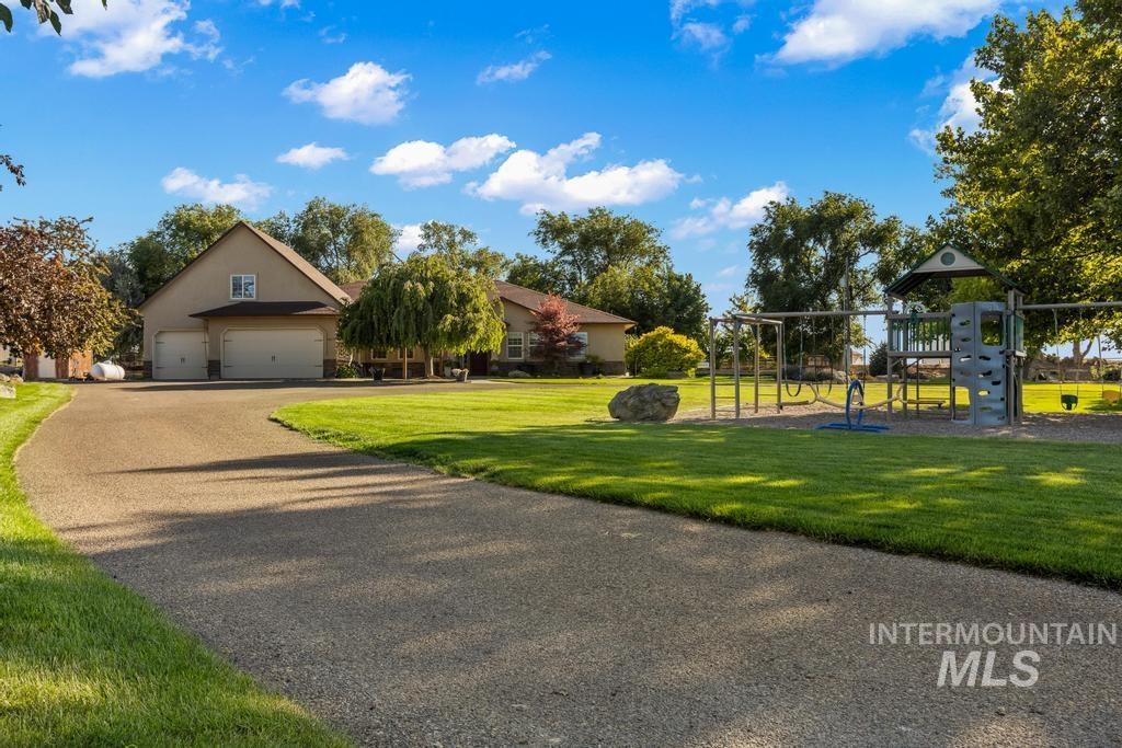 28279 Pearl Road Parma, ID 83660 - Photo 1 of 1 View of front of home featuring a front lawn, a garage, and a playground