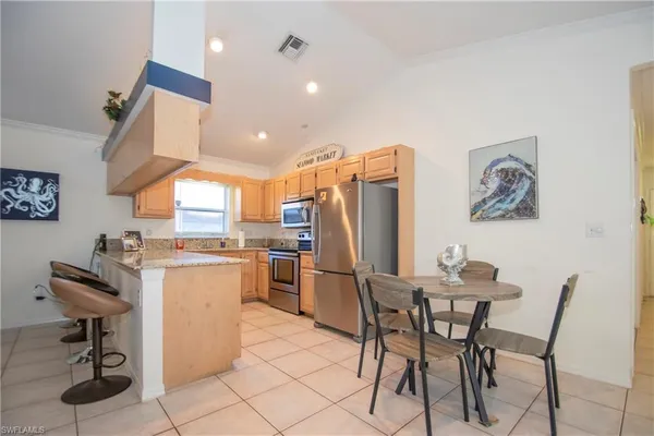 a kitchen with refrigerator and chairs