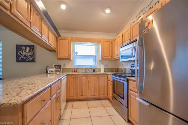 a kitchen with stainless steel appliances granite countertop a sink and a refrigerator