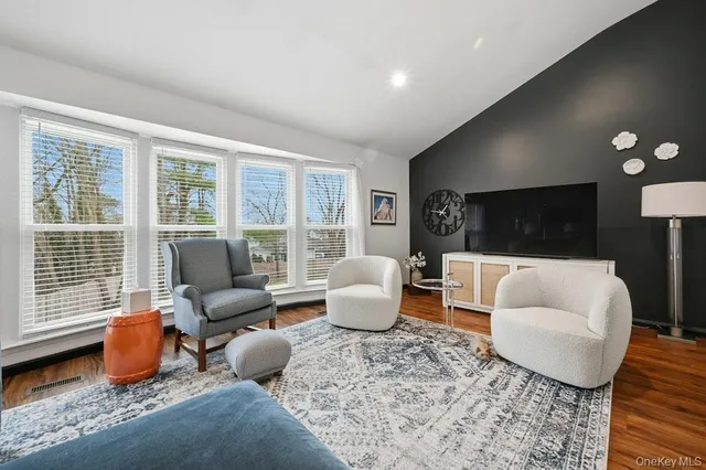 a living room with a couch and a dresser with wooden floor