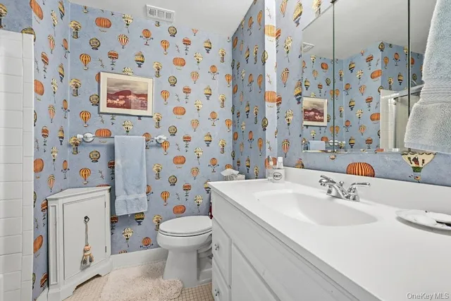 a bathroom with a sink a toilet a mirror and shower