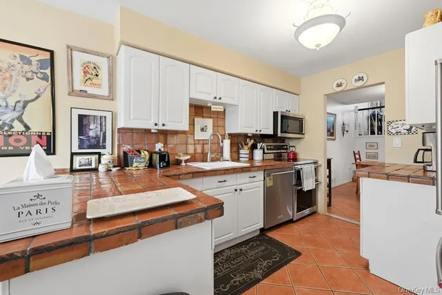 a kitchen with stainless steel appliances granite countertop a sink a stove and cabinets