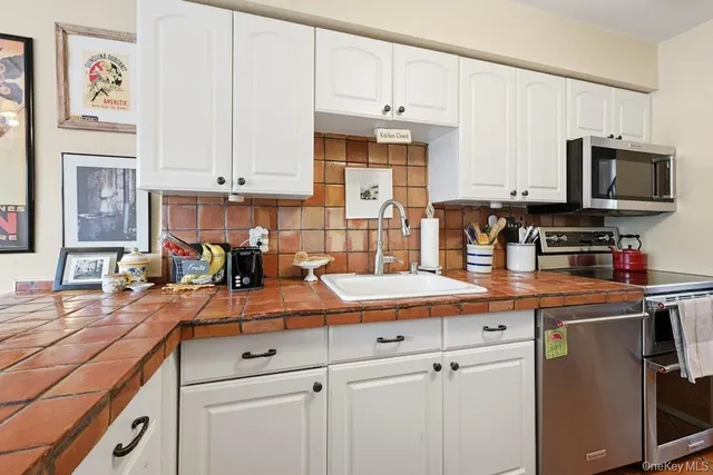 a kitchen with granite countertop a sink stove and cabinets