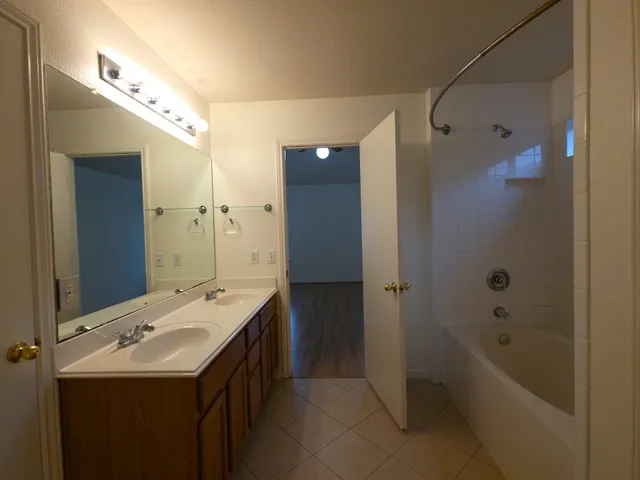 a bathroom with a tub sink shower and mirror