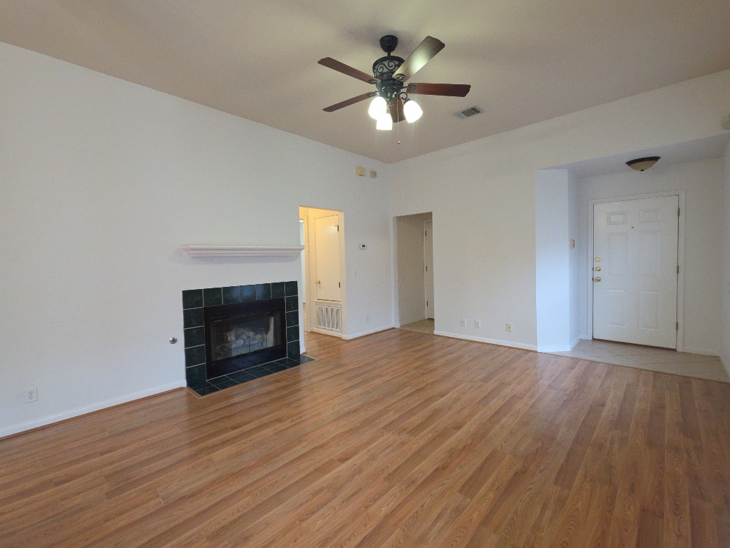 21320 Derby Day Avenue Pflugerville, TX 78660 - Photo 4 of 21 a view of an empty room with wooden floor fireplace and a window