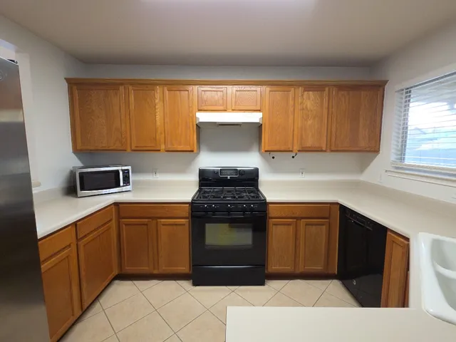 a kitchen with stainless steel appliances granite countertop a stove a sink and a microwave