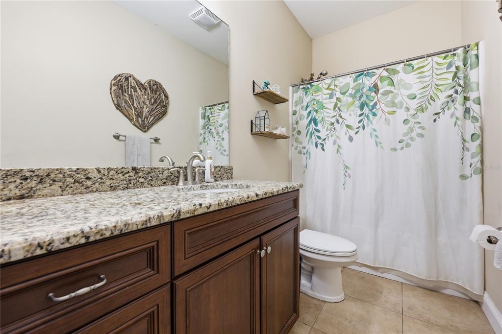 24934 Northwest 170th Road High Springs, FL 32643 - Photo 25 of 33 a bathroom with a granite countertop sink a toilet and a shower