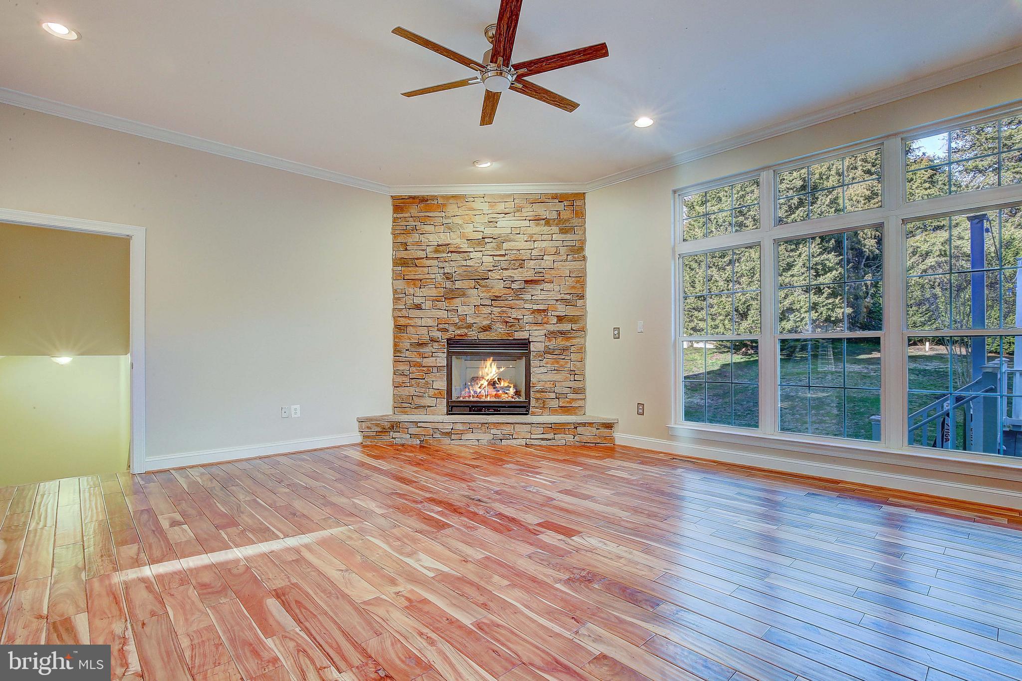 3300 Holland Cliffs Road Huntingtown, MD 20639 - Photo 36 of 93 a view of empty room with wooden floor and fireplace