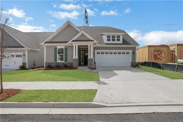 a front view of a house with a garden and yard