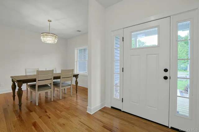 a dining room with wooden floor a glass table and chairs