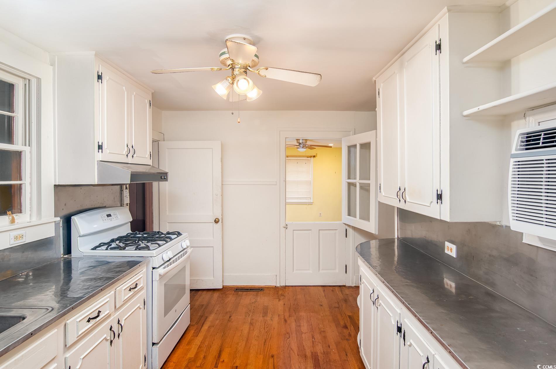 1010 Highmarket Street Georgetown, SC 29440 - Photo 16 of 32 Kitchen with gas range gas stove, stainless steel counters, light wood-style floors, open shelves, and white cabinetry