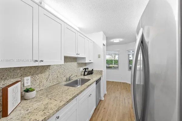 a kitchen with a sink a stove and cabinets