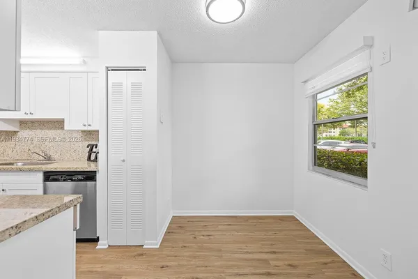 a view of a kitchen with wooden floor and a window