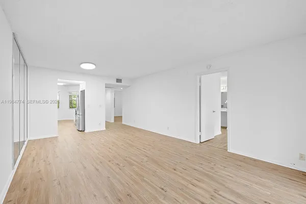 a view of a big room with wooden floor and windows
