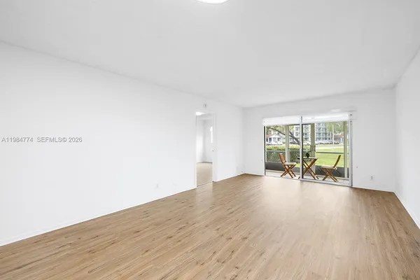 an empty room with wooden floor and a window