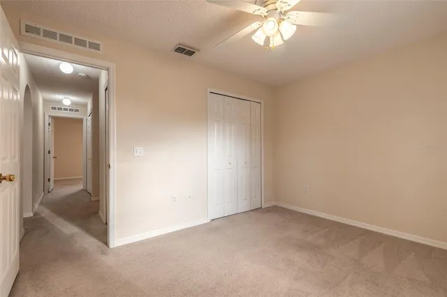 an empty room with windows and fan