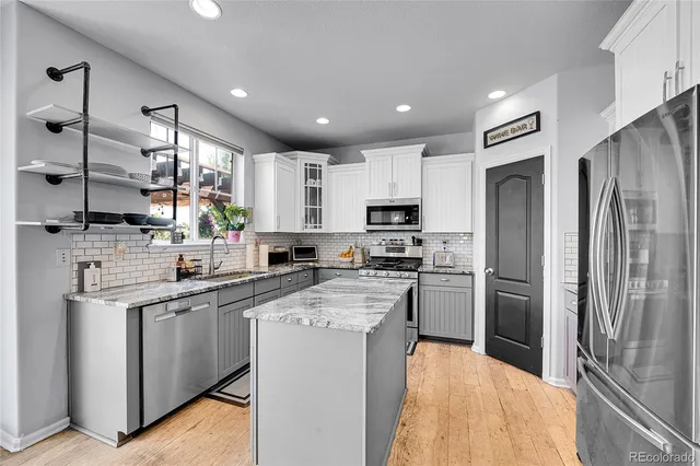 a kitchen with stainless steel appliances granite countertop a refrigerator stove microwave and sink