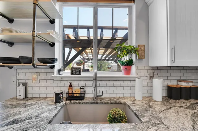 a dining room with stainless steel appliances kitchen island granite countertop a dining table chairs and granite counter tops