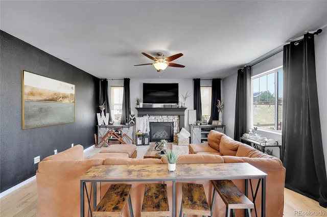 a living room with furniture a flat screen tv and a fireplace