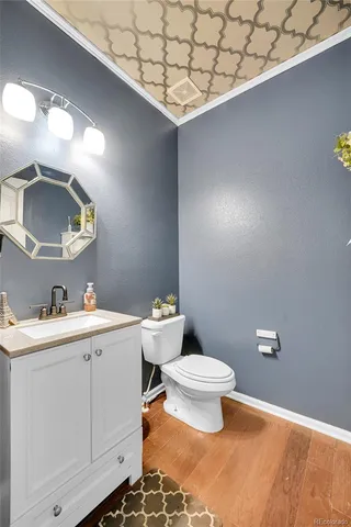 a bathroom with a toilet sink vanity and mirror