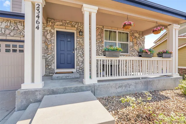 a view of a house with a small yard and wooden floor and fence