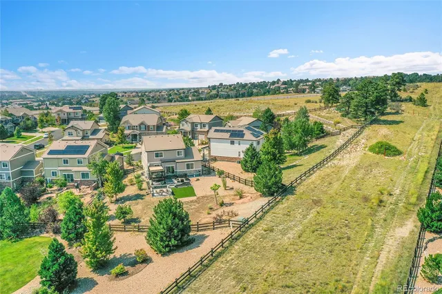 an aerial view of residential houses with outdoor space and ocean view