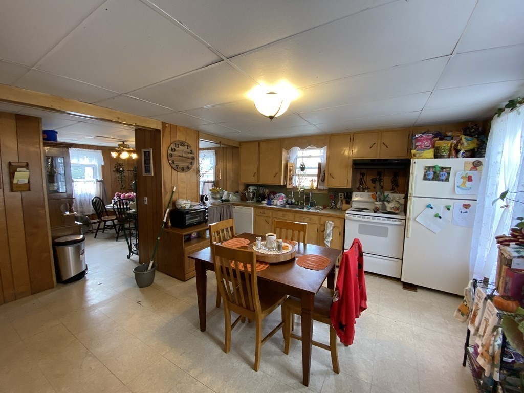 3 Chestnut Street Dudley, MA 01571 - Photo 9 of 20 a kitchen with a refrigerator a stove a dining table and chairs