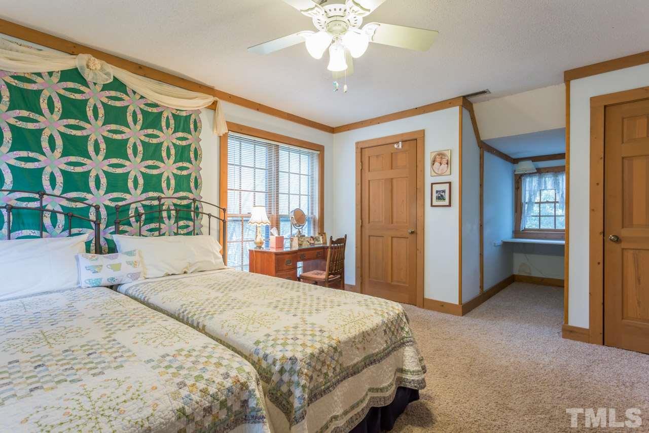 11816 Possum Track Road Raleigh, NC 27614 - Photo 17 of 25 a bedroom with a large bed and a chandelier